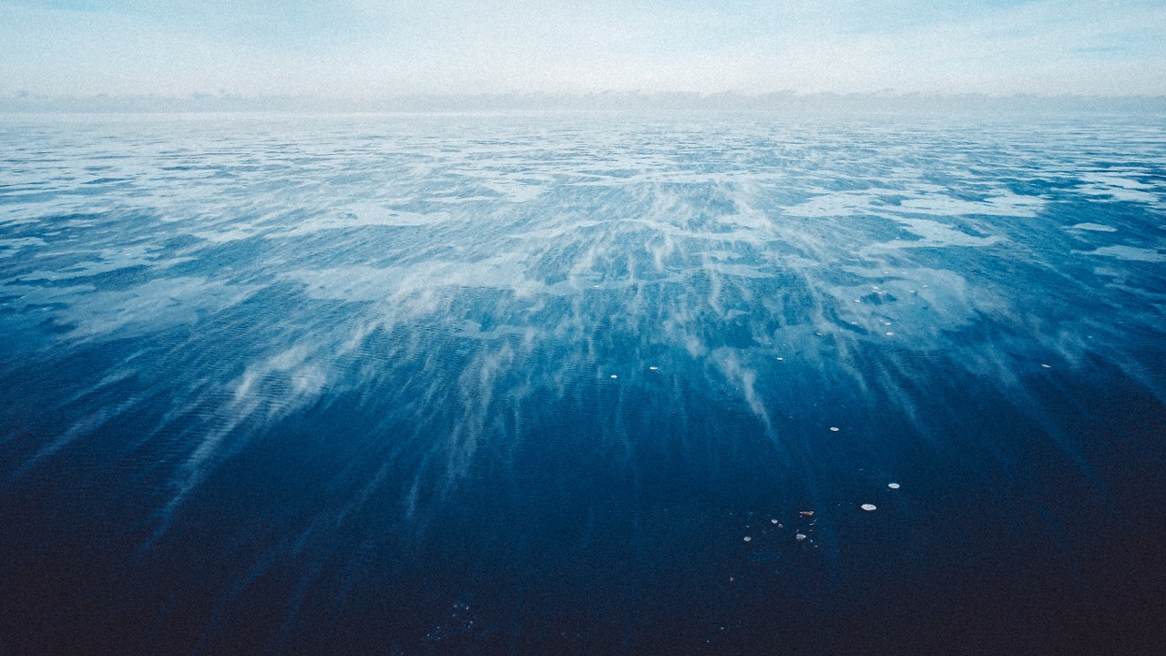 Drone view of frozen Lake Michigan under winter haze.